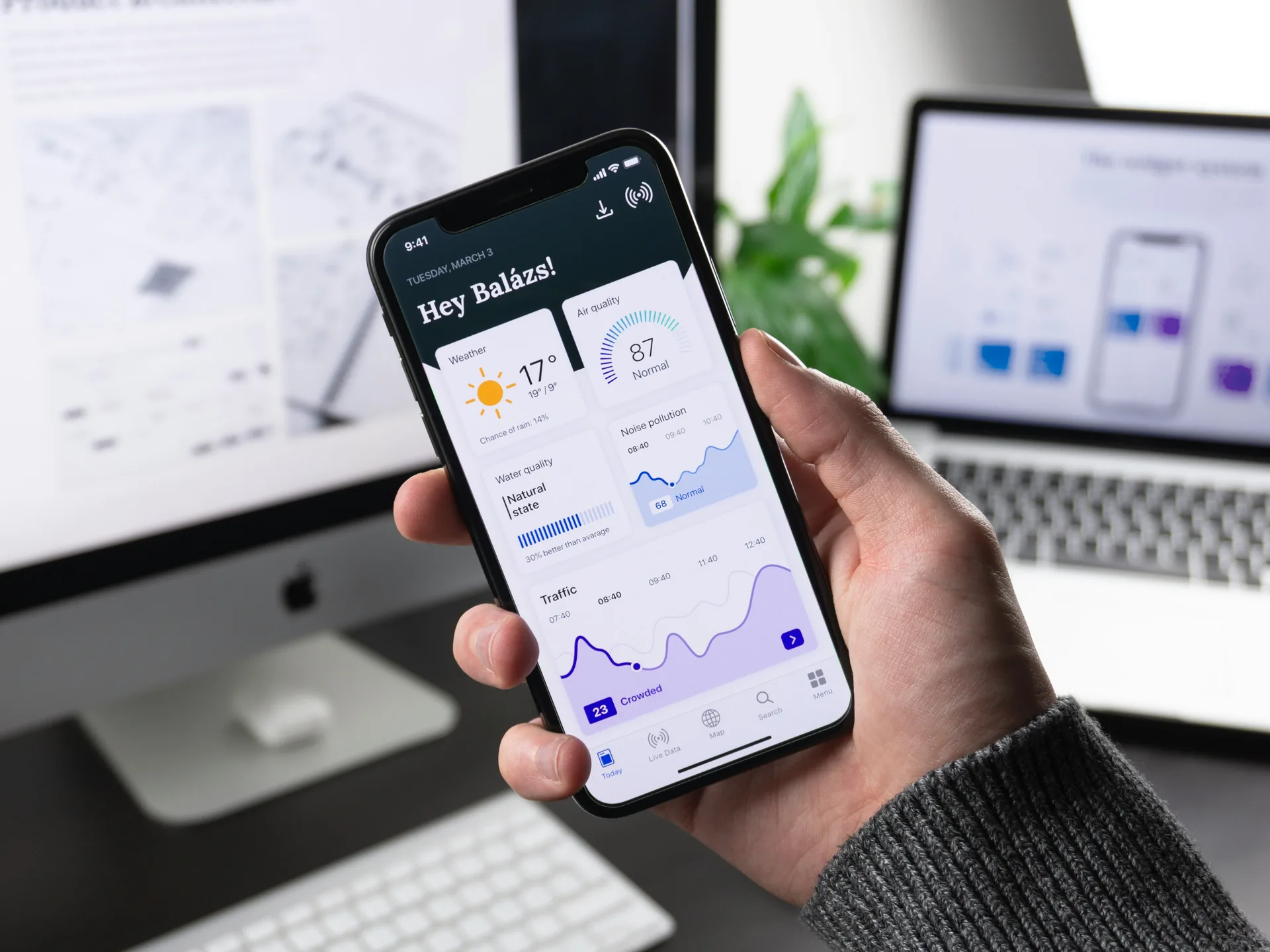 Hand holding a phone showing a mobile dashboard
